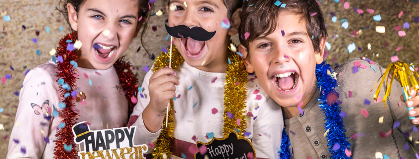 Three happy kids celebrating new years eve at home