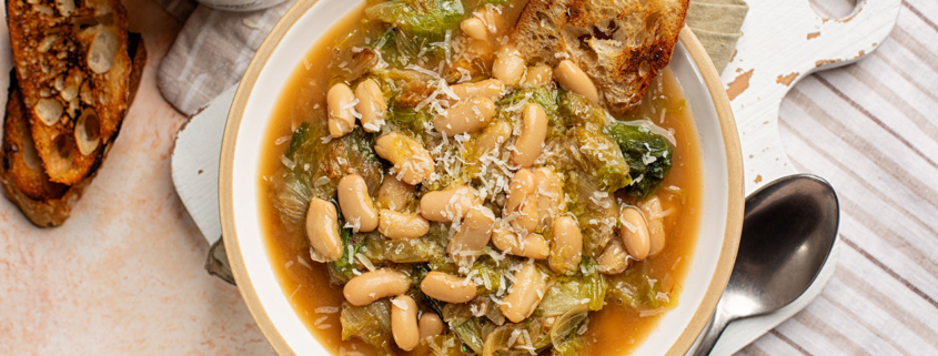 White Bean Cannellini Escarole Soup with cheese and toast bread. Top view. Vegetarian meal