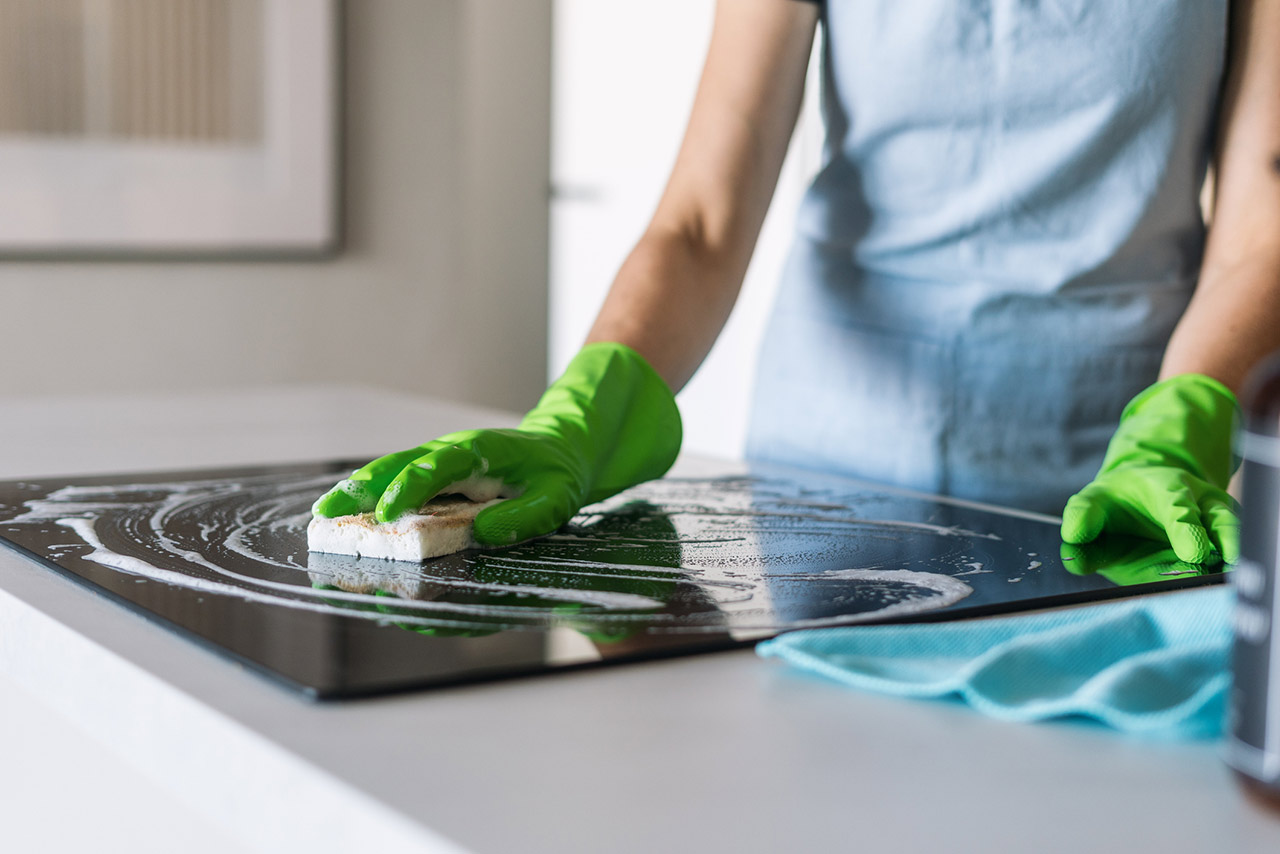 Efficient cleaning of a modern induction stove in a stylish kitchen stock photo
