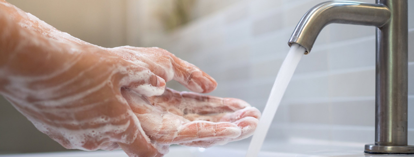 Close up of women washing her hands with soap in a sink