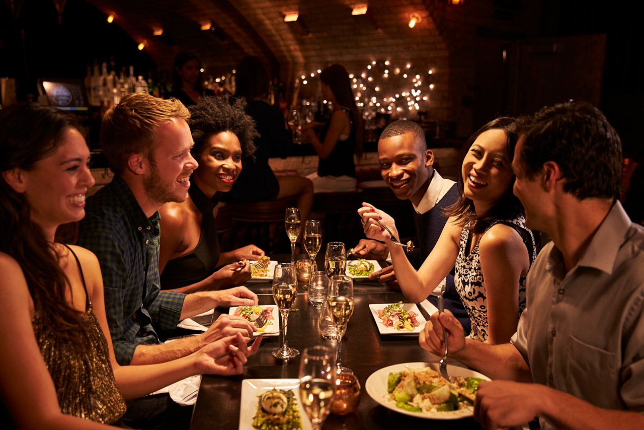 Group Of Friends Enjoying Meal In Restaurant stock photo