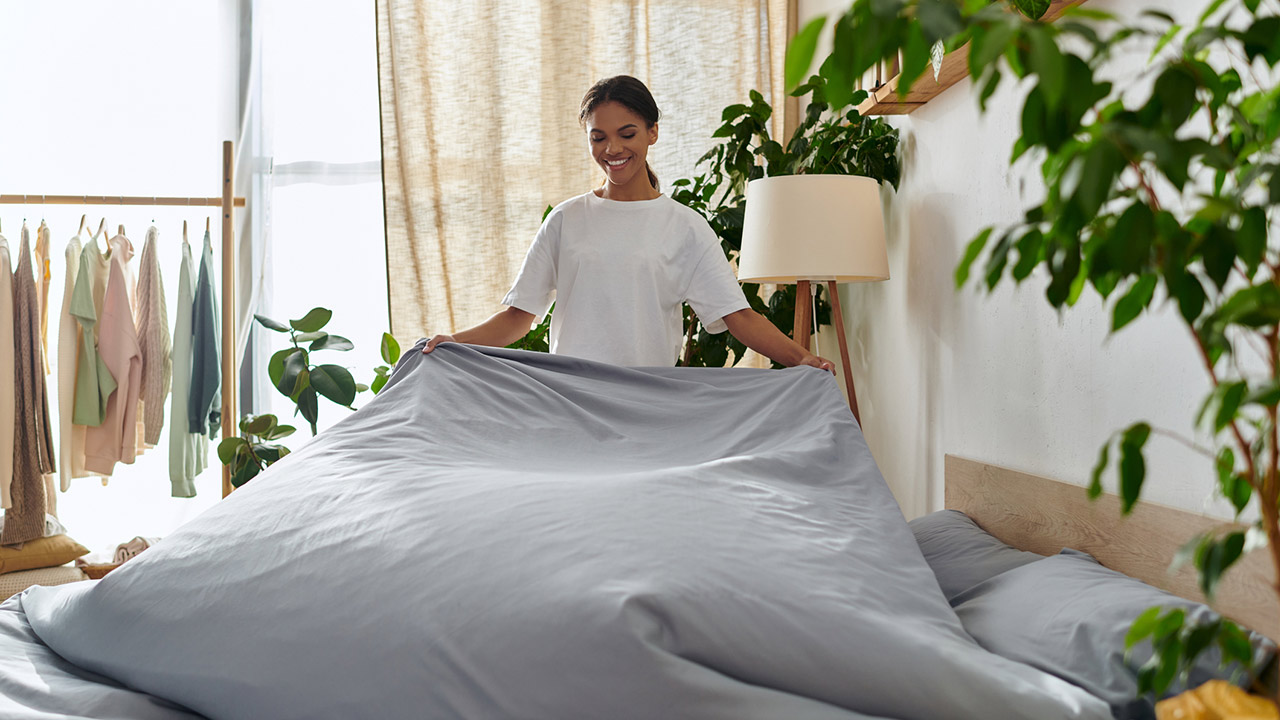 Young african american making a bed stock photo