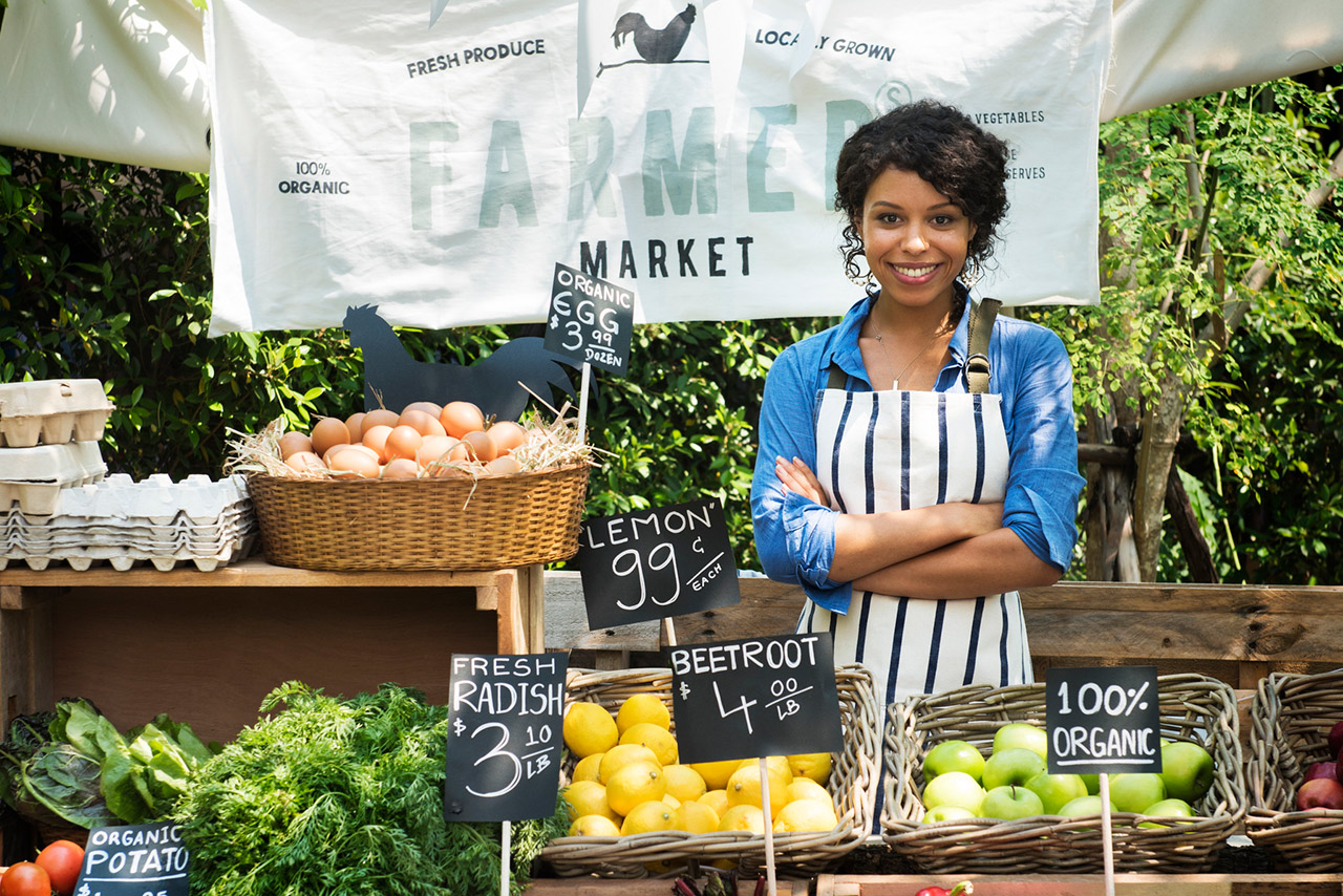 Greengrocer selling organic fresh agricultural product at farmer market stock photo