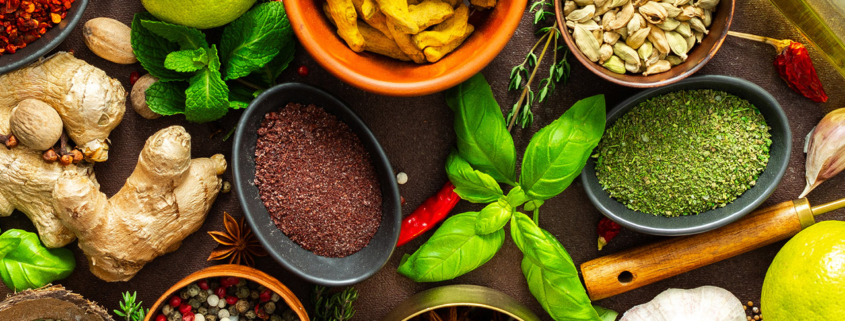 A visually striking arrangement of fresh spices and herbs on a brown surface