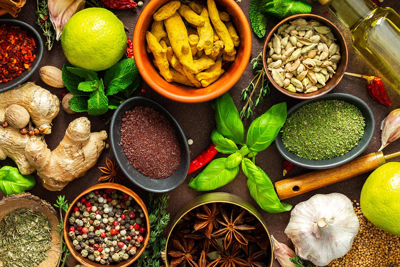 A visually striking arrangement of fresh spices and herbs on a brown surface