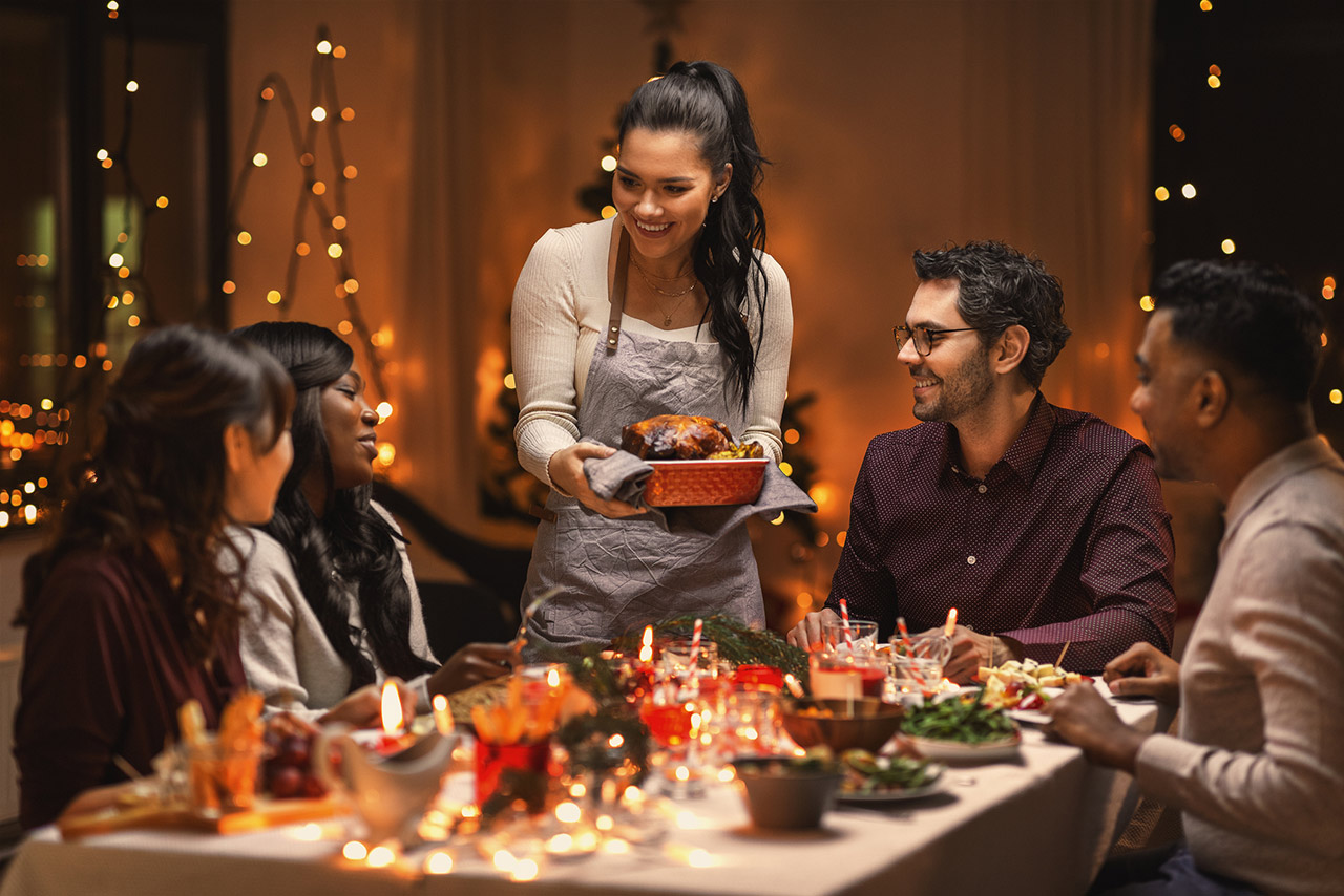 multiethnic group of happy friends having dinner at home