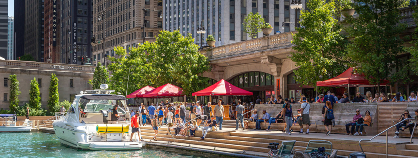 People walking along The Cove, a part of the Riverwalk public space on the Chicago River
