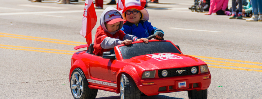 Young children parading in a toy car during The Polish Consitution Day Parade in Chicago