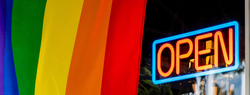 Pride flag and business open sign stock photo