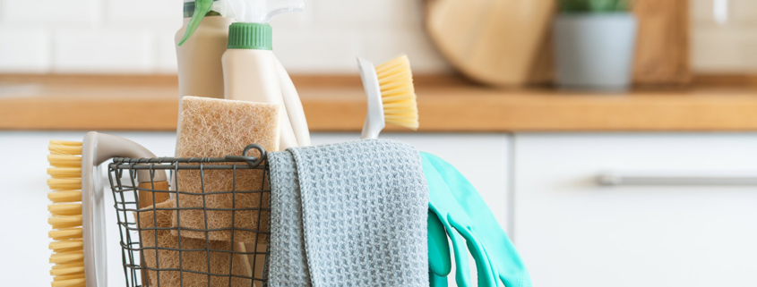 Basket with brushes, rags, natural sponges and cleaning products stock photo