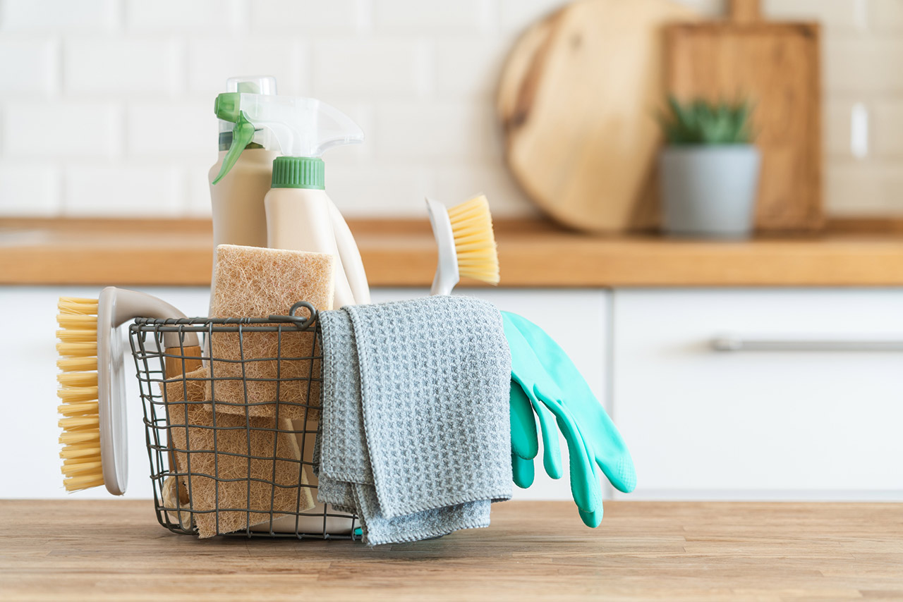 Basket with brushes, rags, natural sponges and cleaning products stock photo