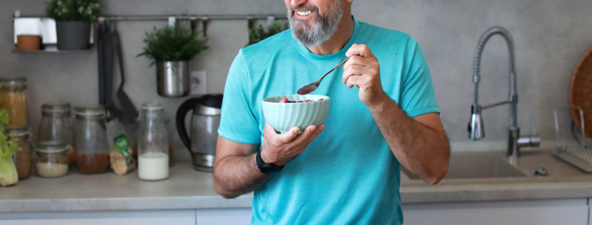 Stock photo of a happy senior mature mid aged man having a healthy breakfast