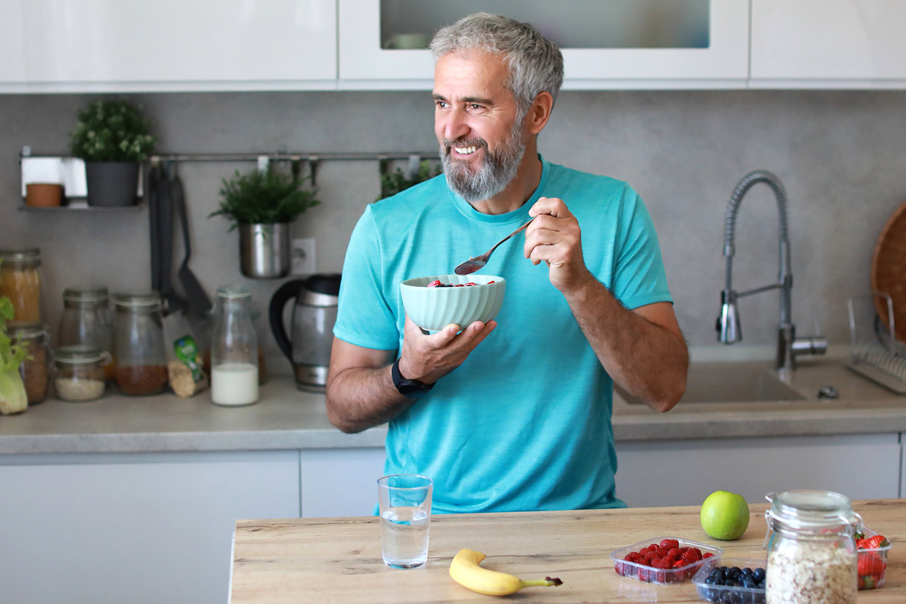 Stock photo of a happy senior mature mid aged man having a healthy breakfast