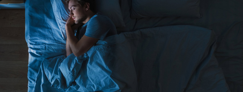Top View of Handsome Young Man Sleeping Cozily on a Bed stock photo
