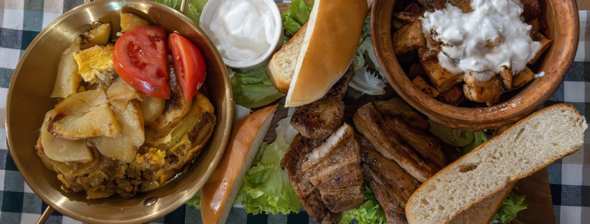 grilled meat, potatoes, tomatoes, and yogurt sauce stock photo