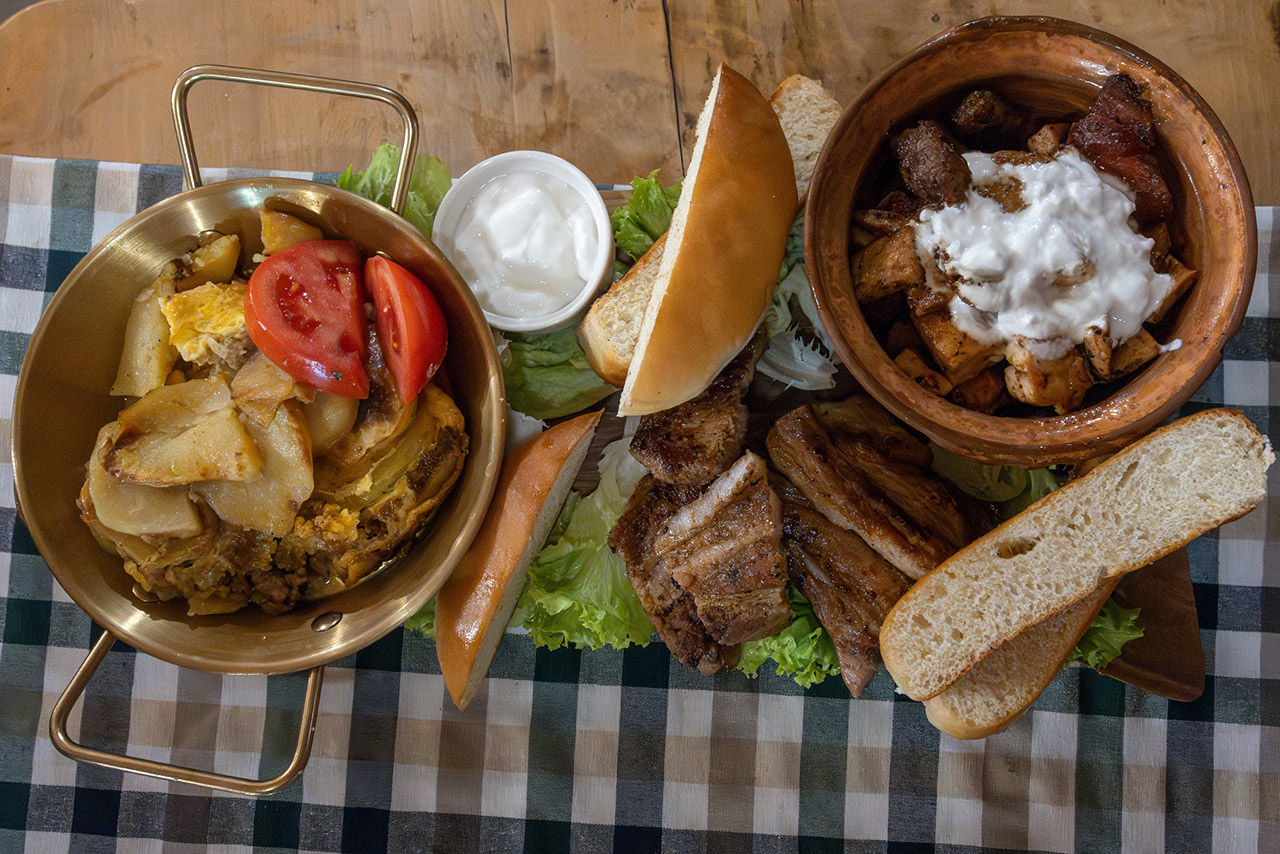 grilled meat, potatoes, tomatoes, and yogurt sauce stock photo