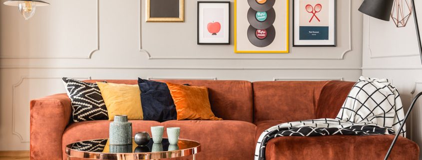 Eclectic living room interior with comfortable velvet corner sofa with pillows stock photo